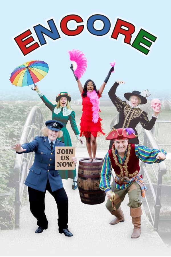 A group of people in theatrical costumes are posing together. A woman in a blue uniform holds a Join Us Now sign.