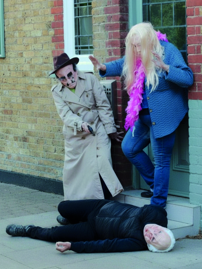 Improvised Murder. Three people are depicted in masks. One is lying on the ground and another holding a gun to suggest a staged crime.